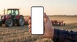 © ArtSync Studio - Farmer Displaying Mobile Phone with Tractor in Field for Agricultural Technology