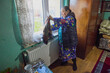 © czamfir - An old country woman in her house is getting ready to go out into the countryside.