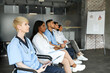 © Prostock-studio - Side view of multiracial group of professional male and female doctors having medical conference at clinic, medical staff attending morning breefing, listening to speech, copy space