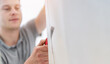 © AA+W - Handyman Man wallpapering working with tools - DIY home work concept