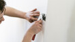 © AA+W - Handyman Man wallpapering working with tools - DIY home work concept