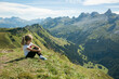 © Mikka - girl sitting on a high mountain with breathtaking view