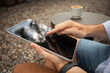 © Atlas - Person engages with a tablet while seated in nature
