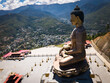 © AmazingAerialAgency - Aerial view of the Great Buddha Dordenma statue standing majestically against a backdrop of rolling hills and a sprawling city, Thimphu, Bhutan.