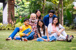© StockImageFactory - Indian family of three generations smiling and bonding outdoors on green park lawns