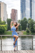 © Andrey_Arkusha - Young beautiful brunette woman in blue knitted dress posing in summer park