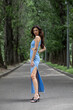 © Andrey_Arkusha - Young beautiful brunette woman in blue knitted dress posing in summer park