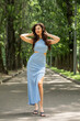 © Andrey_Arkusha - Young beautiful brunette woman in blue knitted dress posing in summer park