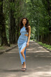 © Andrey_Arkusha - Young beautiful brunette woman in blue knitted dress posing in summer park