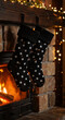 © NeuroCake - Black polka dot Christmas stockings hanging by a cozy fireplace with a burning fire. Festive holiday home interior for a warm winter celebration
