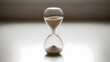 © Genesis - Hourglass on a reflective surface representing time passing and concept of deadline