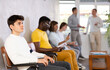 © JackF - Portrait of a young man sitting in a chair in the lobby waiting