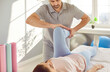 © Studio Romantic - Man therapist, provides targeted physiotherapy, including a leg and knee massage, during a rehabilitation session for a woman. Physical therapy, benefits of stretching and sports medicine.