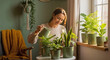 © Olga - Woman watering indoor plants at home in cozy natural light