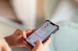 © Kateryna Muzhevska - Close-up of hands using smartphone for messaging with colorful chat interface displayed
