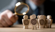 © sornram - A businessman examines target figures through a magnifying glass, emphasizing focus and strategy in decision-making.