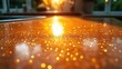 © sumi - Reflected sunset light creating bokeh effect on a shiny dark brown flat surface