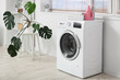 © Pixel-Shot - Washing machine with clean towels and bottles of detergent in laundry room