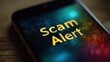 © Oulaphone - A smartphone screen displays a warning message: 'Scam Alert,' highlighting concerns about online security and potential fraud.