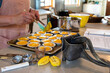 © Cavan - Hands filling lemon tarts with curd in a bright spring kitchen
