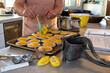© Cavan - Woman spooning lemon curd into tart shells on kitchen counter
