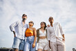 © Bliss - Young friends enjoying a fun rooftop party together under a clear blue sky