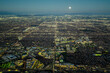© Monet_P - Aerial view of illuminated Los Angeles grid at night under a full moon, showing vast urban sprawl, streets, and city lights extending to the horizon across Southern California