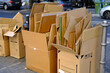 © kittyfly - broken cardboard boxes with waste paper, next to paper recycling bin recycling problem, urban waste management, raw material for recycling, environmental contamination and neglect