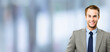 © vgstudio - Portrait - happy smile confident business man in grey suit jacket, blue shirt, tie, against blurred office background. Businessman, bank manager, lawyer, teacher. Banner image with free ad text space