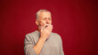 © RZ Images - Portrait of sleepy senior man yawning looking at camera isolated on red background