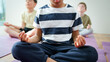 © Monkey Business - Close Up Of Group Of Elementary School Pupils Sitting On Floor And Meditating