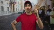© Krakenimages.com - Man touches cap and points finger upward on street lined with blurred pedestrians; curiosity insight.