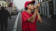 © Krakenimages.com - Lifeguard man in red shirt and cap blowing a whistle and raising both arms on a busy street, calling for attention; vigilance duty.