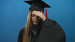© Krakenimages.com - Teen girl wearing mortarboard and graduation gown holds hand on forehead in blue studio; uncertainty doubt reflection hesitation.