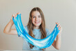 © inna717 - Smiling girl stretches wide the beautiful blue and white marbled slime. Fun sensory activity promoting creativity and relaxation