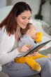 © auremar - mother with baby using digital tablet at home