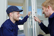 © auremar - tradesmen checking lock on entrance door to appartment