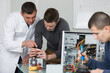 © auremar - students working on computer components with soldering iron and multimeter