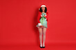 © New Africa - Beautiful woman in Mrs Claus costume with sack on red background. Christmas season