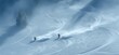 © Aquir - Freeride skiing. Two skiers descending a snowy mountain, kicking up powder snow and leaving tracks