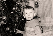 © Nataliia - Vintage portrait of a little boy near a Christmas tree. Retro photo from 1970.