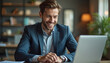 © Viktor - Handsome businessman smiles confidently at laptop in modern office. Young male pro happy working, enjoying positive online communication, video call. Entrepreneur achieving business success,