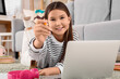 © Pixel-Shot - Happy teenage Asian girl with laptop doing tasks on online lesson at home