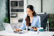 © laddawan - Businesswoman Analyzing Finance on Tablet and Laptop at Office Desk tax, report, accounting, statistics, and analytical research concept