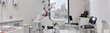 © Seventyfour - Empty modern dental office showing dental chair and equipment prepared for patients attending dental appointment, clean clinical environment with large window and marble floor, header