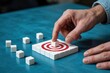 © Media Srock - Individual places a white cube precisely onto the center of a red and white target built from small blocks