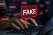 © tadamichi - Fake news and misinformation on social media. Malicious disinformation and Clickbait content. Man using laptop computer to spread false information.