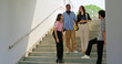 © Raushan_films - Indian young adult gen z guy girl boy hold tab talk gossip spend day enjoy break time outdoor place. Happy relax teen male female man lady group standing on stair speak new plan share funny joke humor