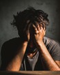 © Dani - Depressed Man Hiding Face in Hands in Dark Mood. Portrait of a man sitting alone with head in hands, expressing deep sadness, depression, and mental distress. Emotional representation of psychological