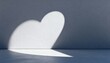 © Futuristictech - Single Light Source Casting Heart Shaped Shadow on Minimalist Surface for Modern Design and Artistic Presentation